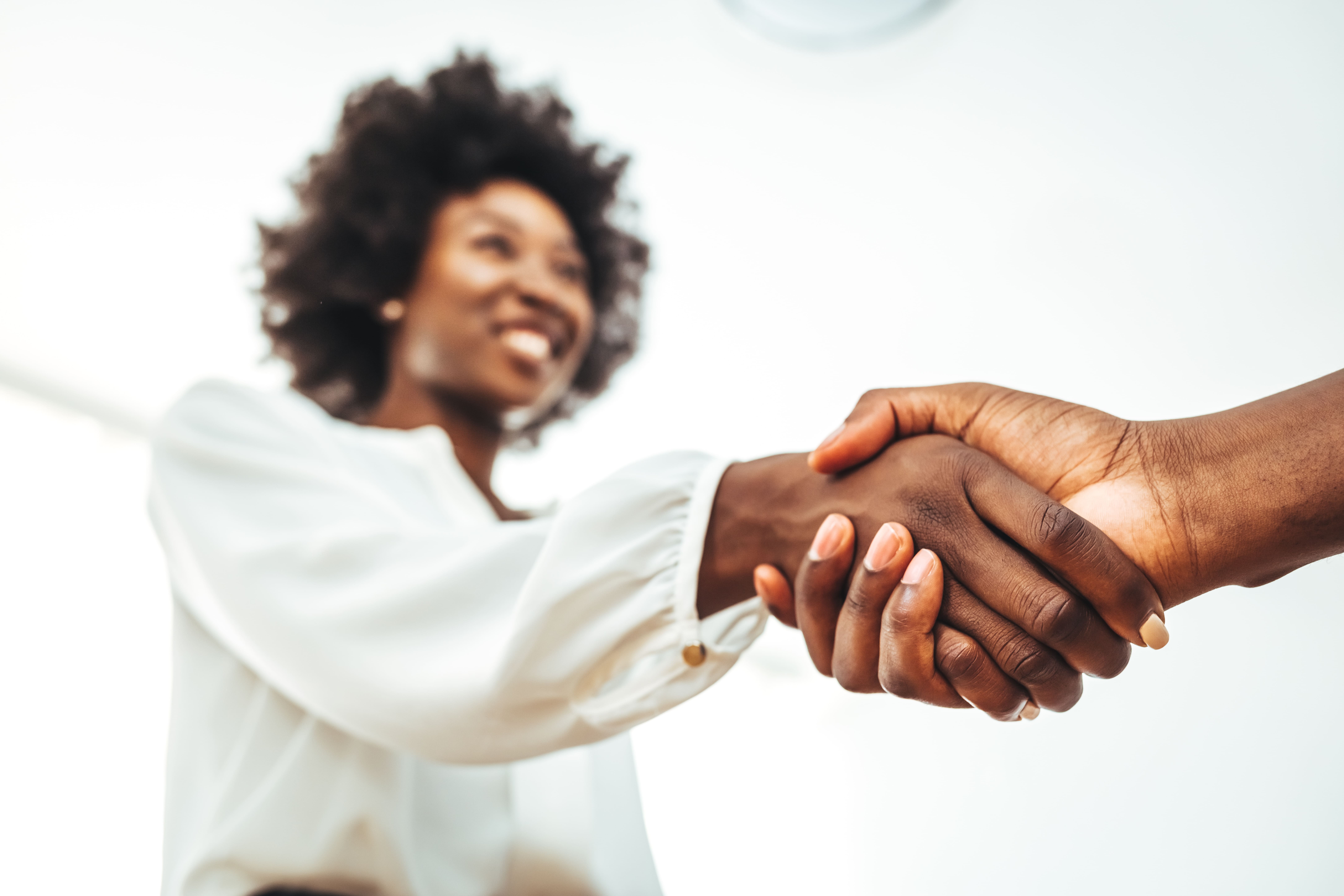 Actions-partenariales-cgss-guyane Femme souriante serrant la main d'une personne