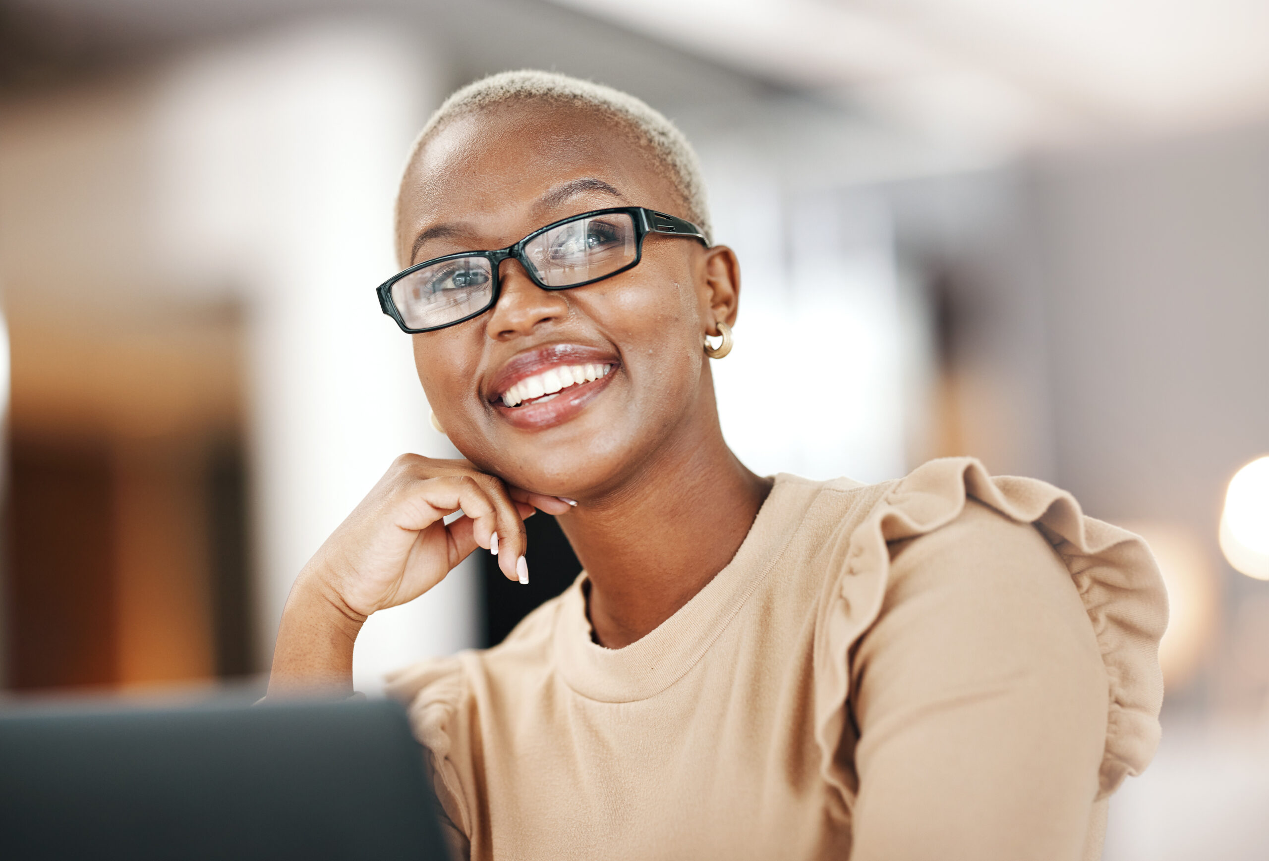 Black woman, thinking and smile, relax at desk with laptop for content creation ideas at digital marketing startup. Copywriter, happy female and contemplating with inspiration for copywriting job.